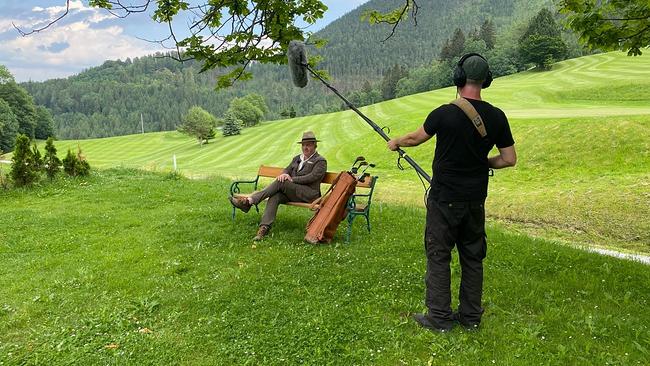Dreharbeiten mit Cornelius Obonya auf dem Gipfelkreuz Hochschneeberg: Cornelius Obonya steht am Gipfel, die Kamera ist auf ihn gerichtet.